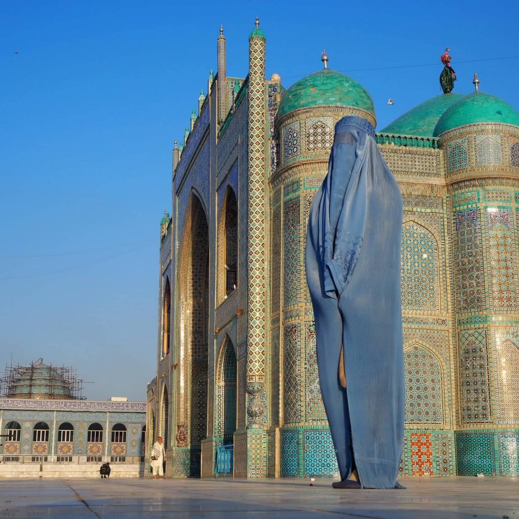 donna di profilo in burqa davanti a moschea in afghanistan